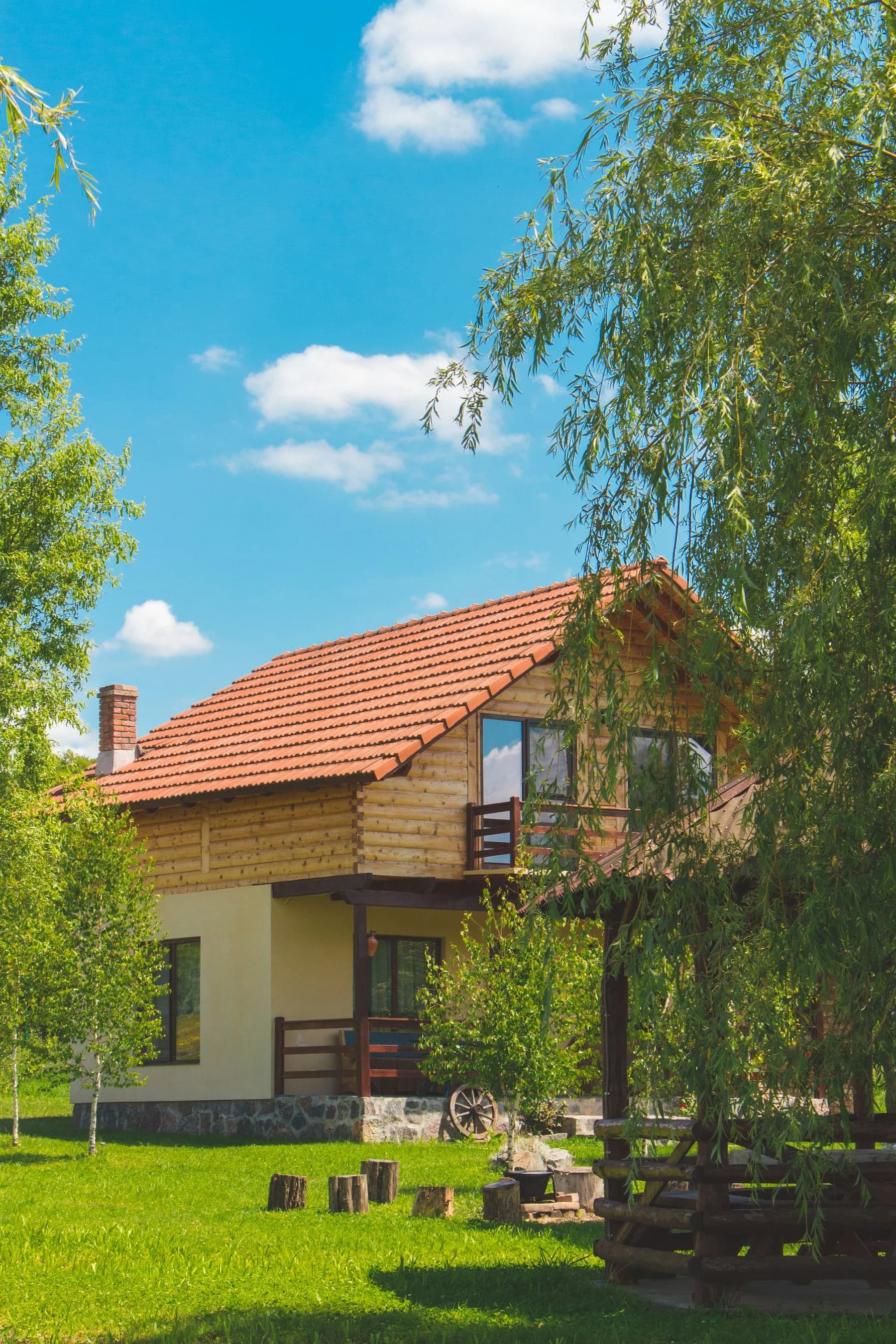 A timber-clad home beside leafy trees; illustrative stock photography, not a Broom Home listing.
