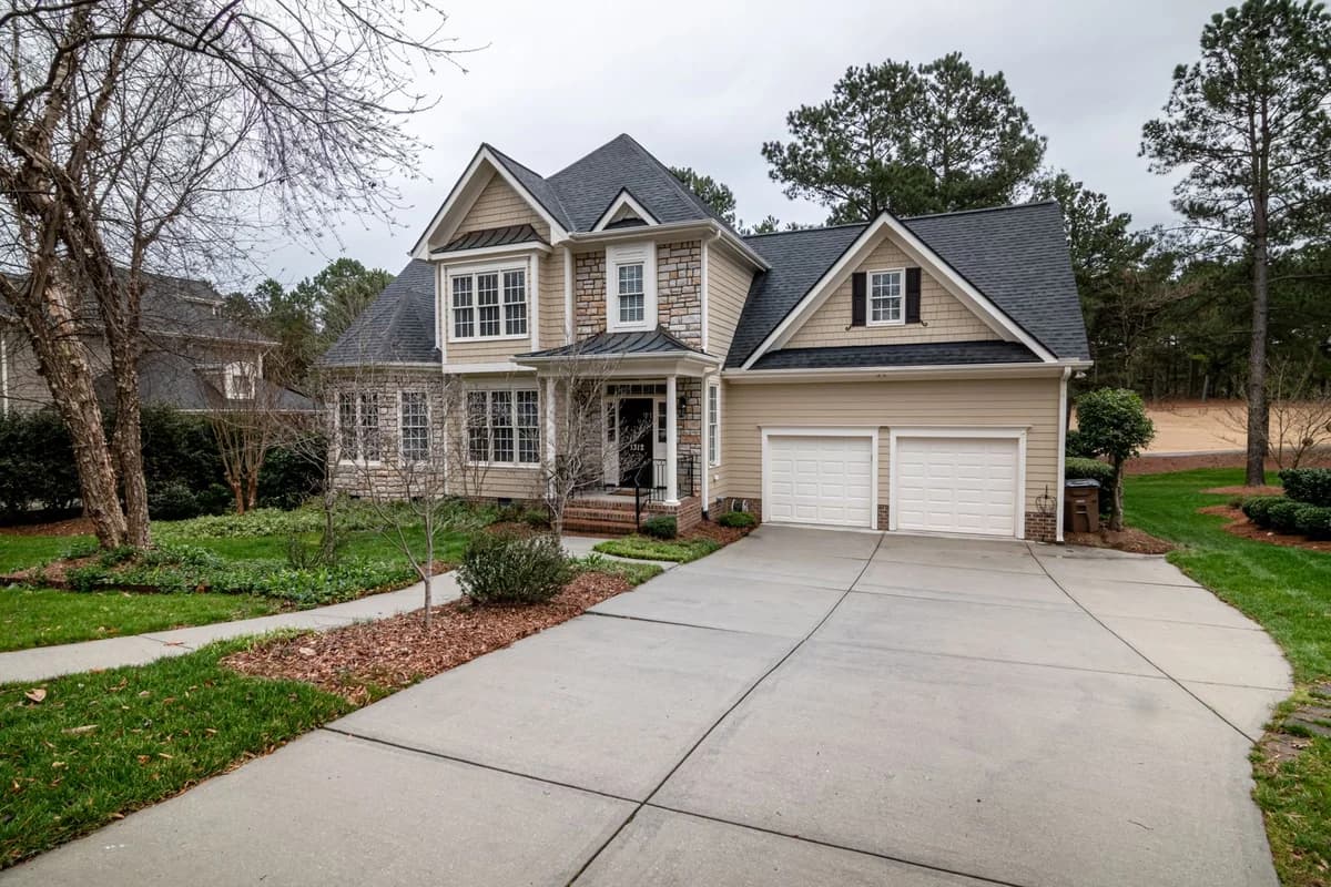 A two-story family home with a landscaped front garden; illustrative stock photography, not a Broom Home listing.